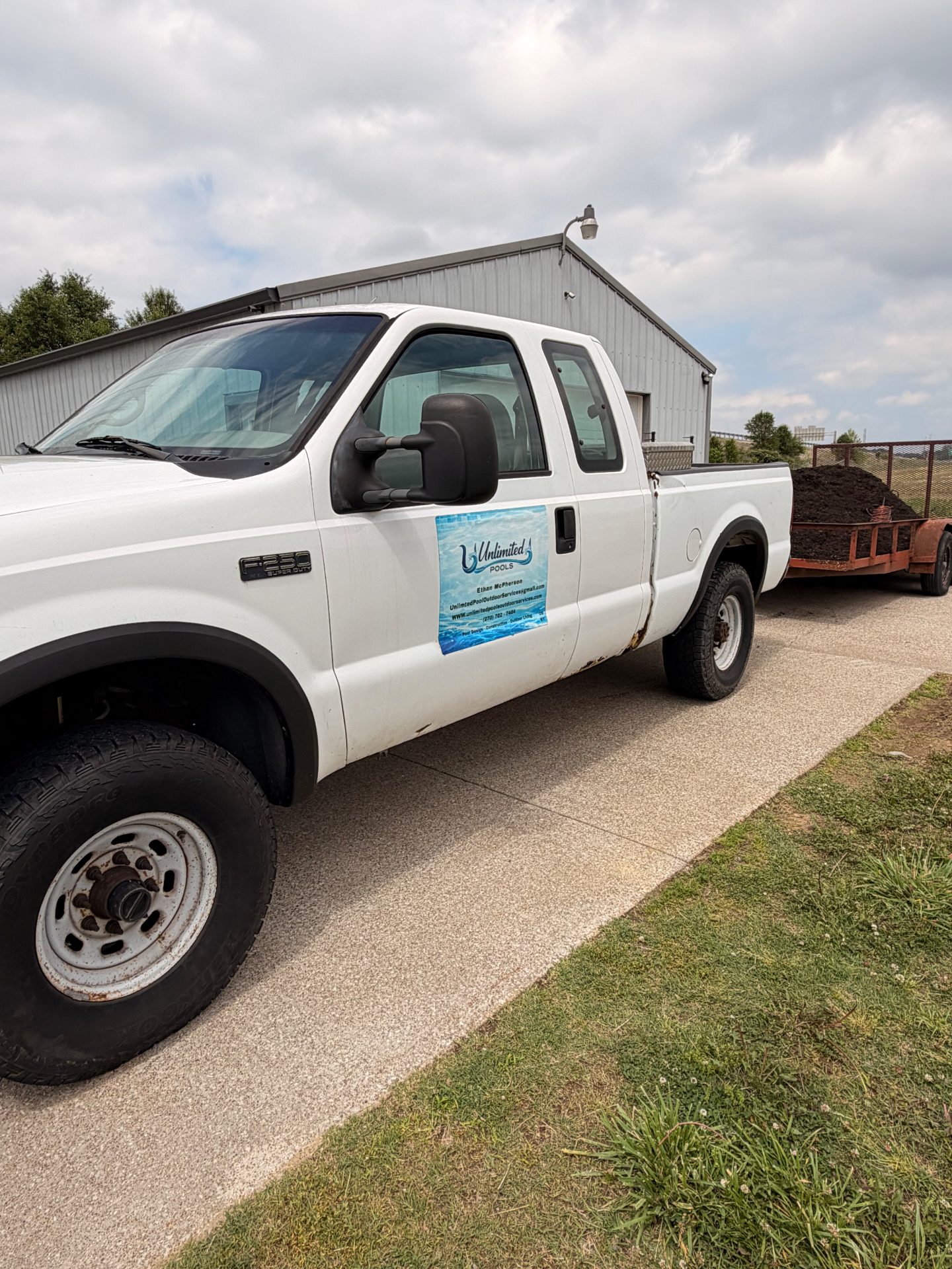 Branded work truck with Unlimited Pools door magnet on a job site in Owensboro, KY